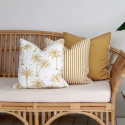 Outdoor seating with 3 mustard coloured outdoor cushions on a couch.