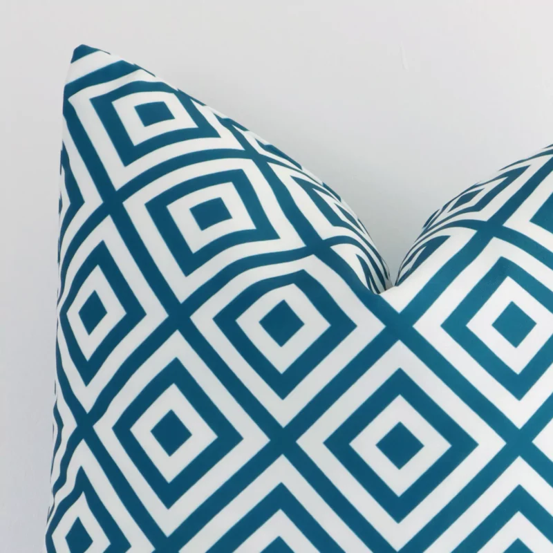 Precision shot of this square teal cushion cover. It is possible to see the geometric style and outdoor fabric in greater depth.