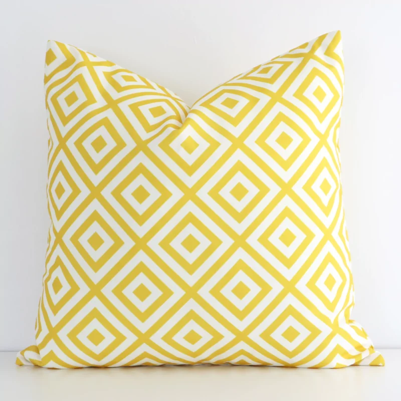 byron-geometric-waterproof-yellow-outdoor-cushion-cover---sc727-45 Bold square yellow cushion positioned in front of a white wall. Its geometric style pops on the outdoor fabric.