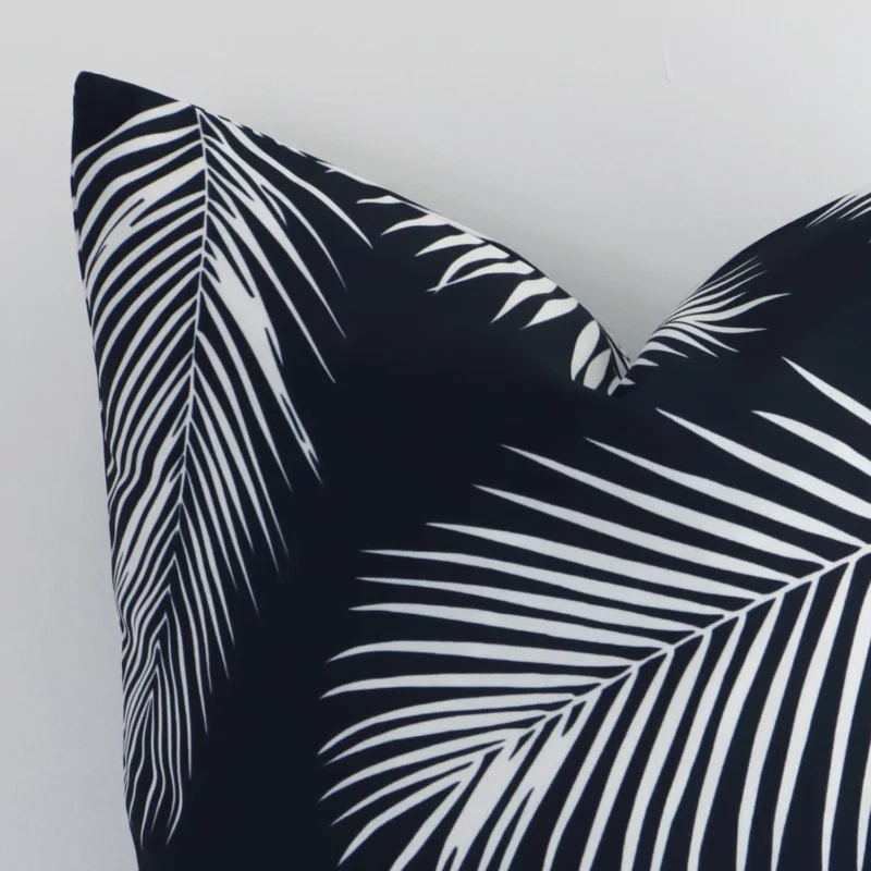 Focused view of palm-designed square cushion cover. The shot shows details of its outdoor material and black and white colour.
