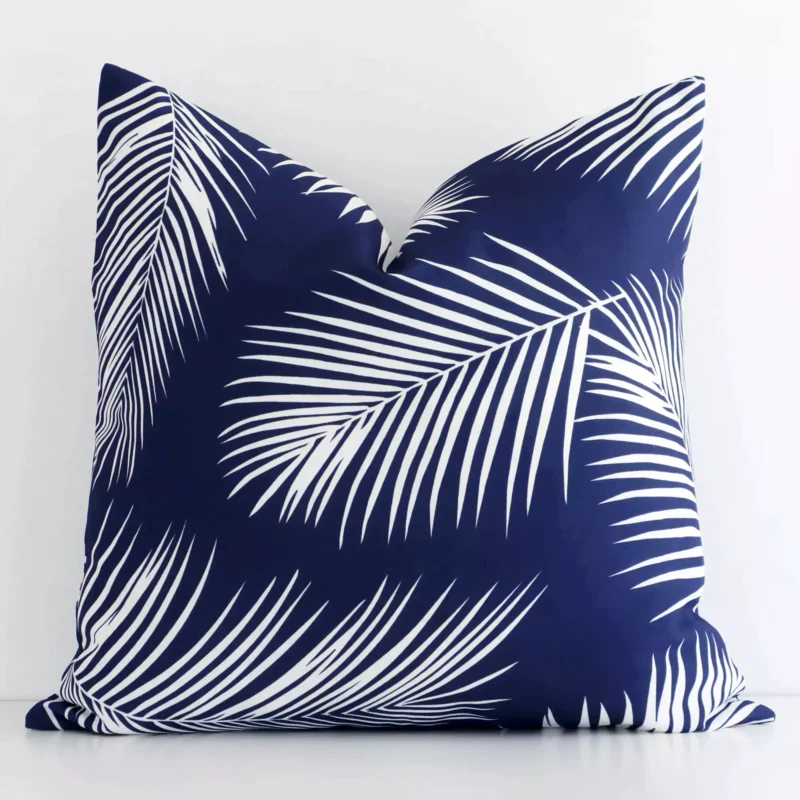byron-palm-waterproof-navy-outdoor-cushion-cover---sc712-45 Navy palm-designed cushion cover sits against a white wall. It is constructed from a superior looking outdoor material and has square dimensions.
