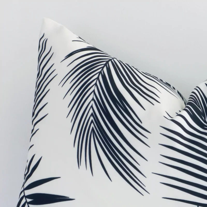 Zoomed in visual of outdoor square cushion cover in black-and-white. The intricacies of its palm design are visible.