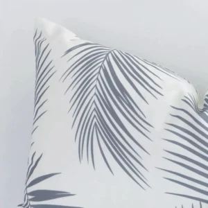 Corner section image showing features of a rectangular grey cushion that has a palm motif on its outdoor fabric.