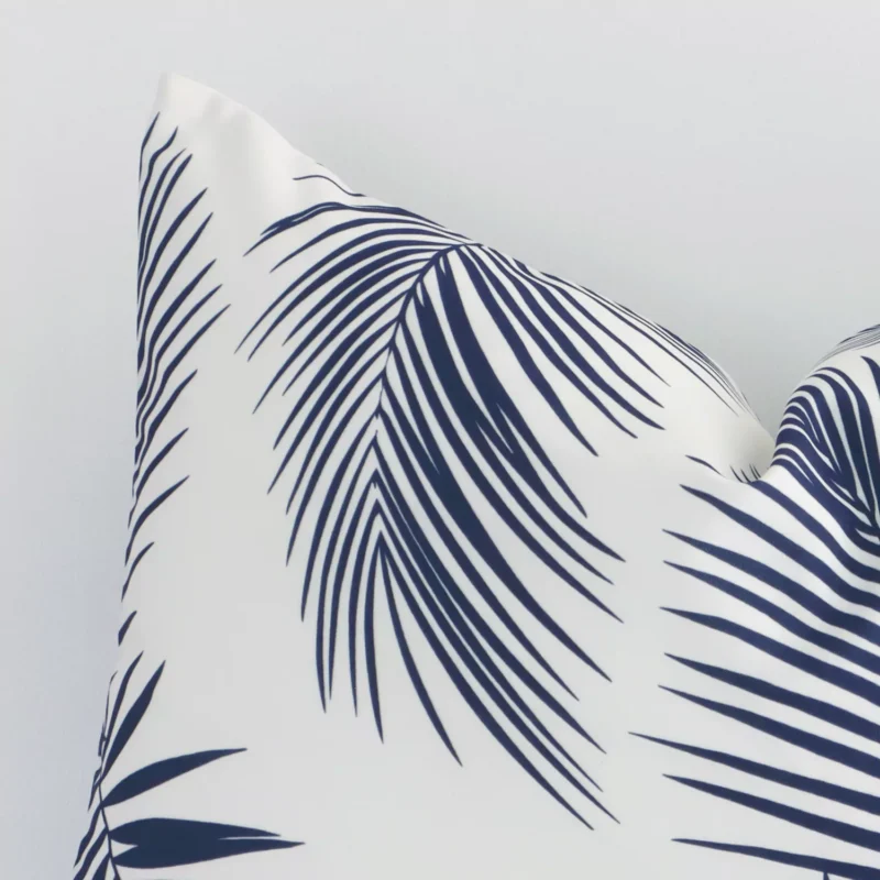 A detailed shot of this navy palm-styled cushion cover that has outdoor fabric and a rectangle shape.