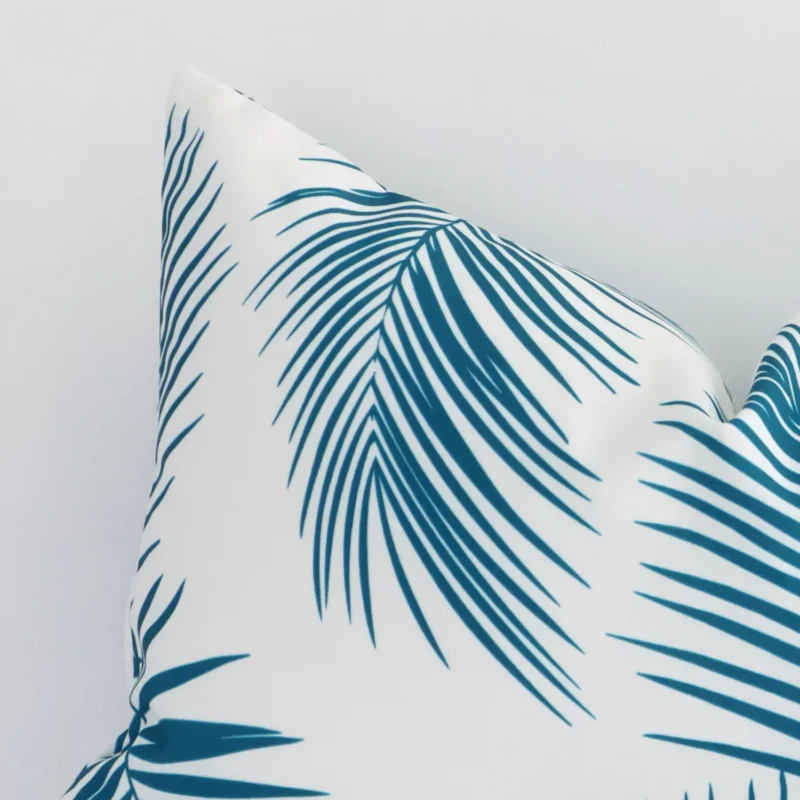 Close up image of top corner of this palm printed teal cushion. This shows the outdoor fabric and its corner up close.