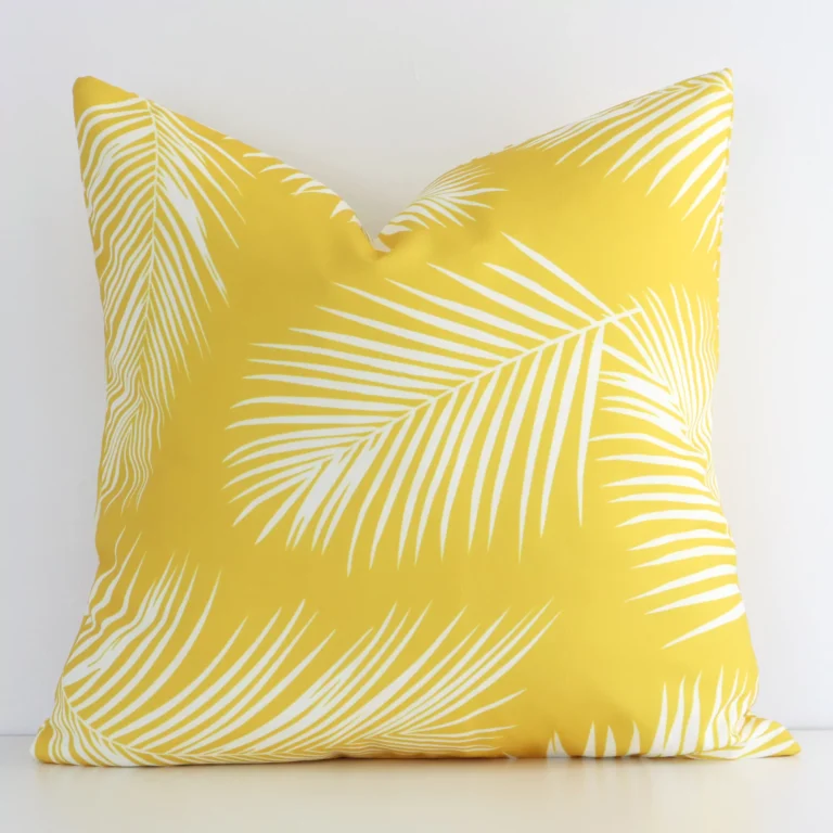 A hero shot of a palm styled square cushion cover. It is made from a deluxe outdoor fabric and features a yellow colour.