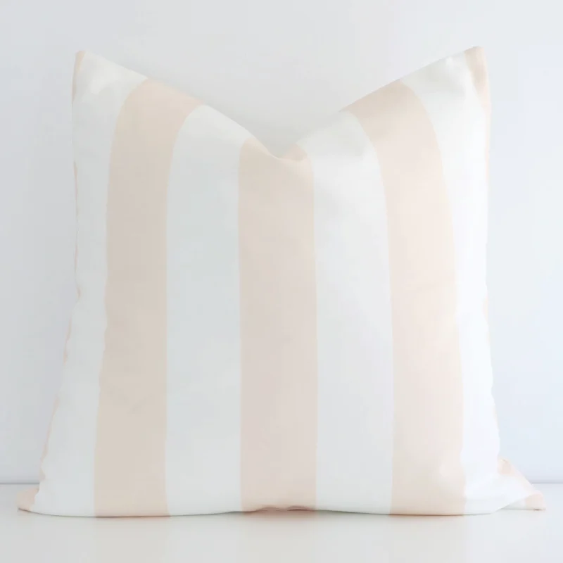 byron-striped-waterproof-beige-large-outdoor-cushion-cover-‚äì-large---sc691-55 Beige cushion positioned in front of a white wall. It has large dimensions and is made from an outdoor material.