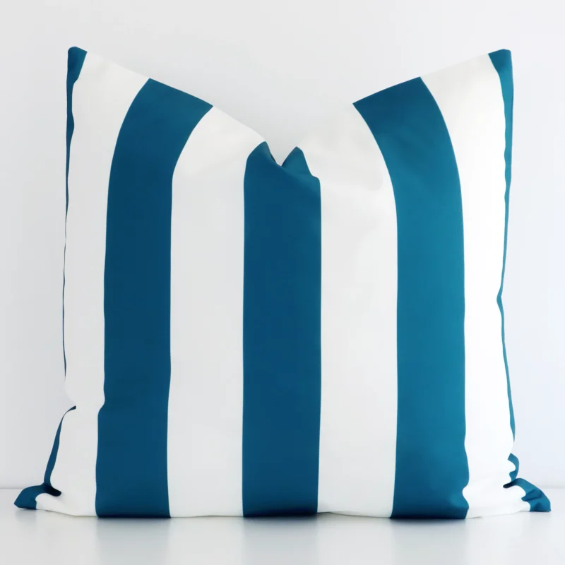 byron-striped-waterproof-teal-large-outdoor-cushion-cover-‚äì-large---sc725-55 A large striped cushion in a delightful teal tone rests against a white wall. The outdoor material appears to be of exceptional quality.