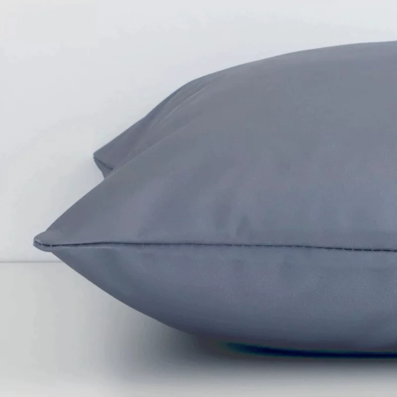 Square grey cushion laid flat. This view shows the solid-coloured style and outdoor fabric from side on.