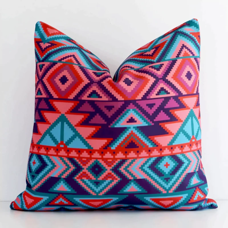 caravan-style-waterproof-outdoor-cushion-cover---sc573-45 White wall with a geometric cushion laying against it. It has a distinctive outdoor fabric and has a square shape.