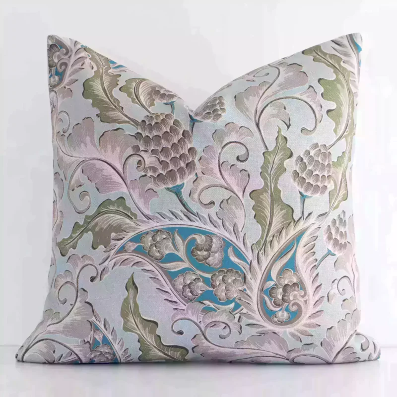 Colourful patterned cushion positioned in front of a white wall. It has square dimensions and is made from a linen material.