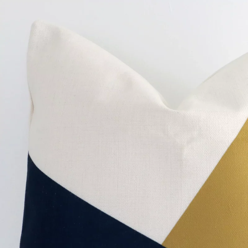 Extreme close up of a square colourful cushion. The geometric style and linen fabric are shown with a much higher degree of detail.
