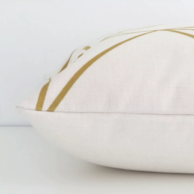 Horizontal edge view of front and back panels of a geometric linen cushion in a square size and with gold mustard print.