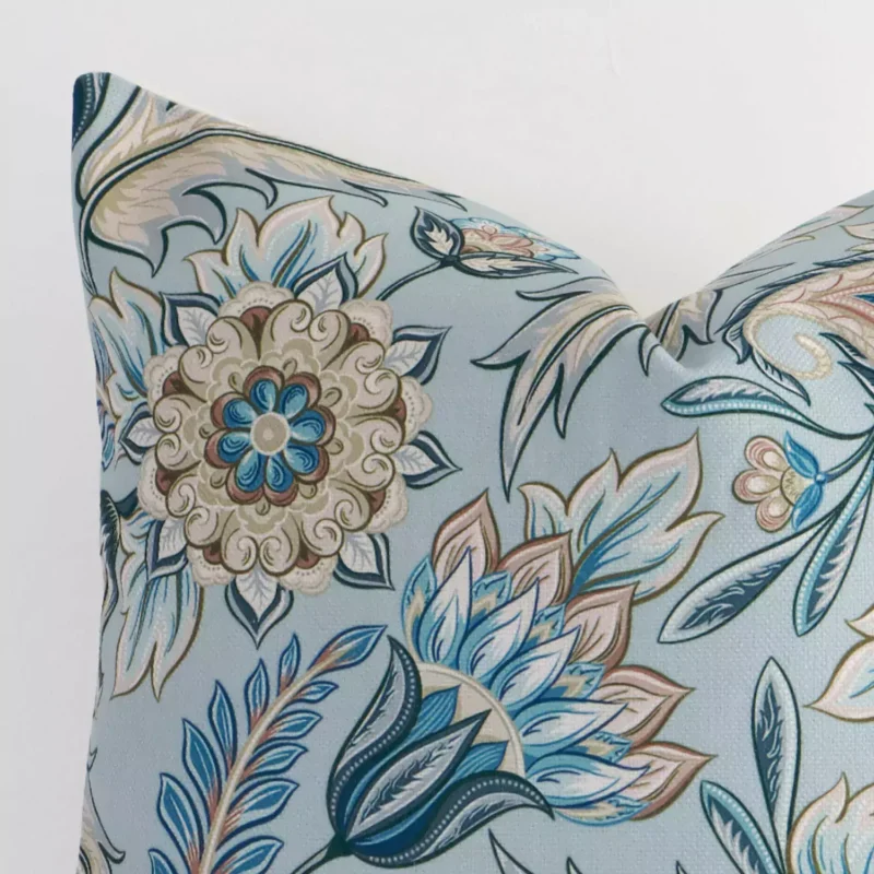 A close up image of this patterned square cushion. The image shows details of its linen fabric and colourful print.