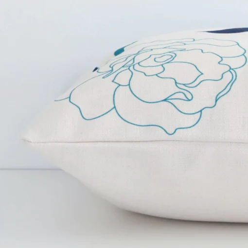 A side shot of a floral linen cushion cover. The angle shows the edge of the square shape and the colourful tone.