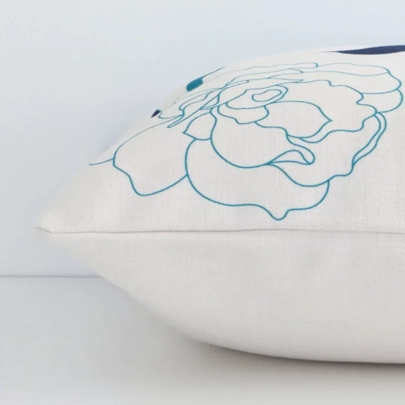 A side shot of a floral linen cushion cover. The angle shows the edge of the square shape and the colourful tone.