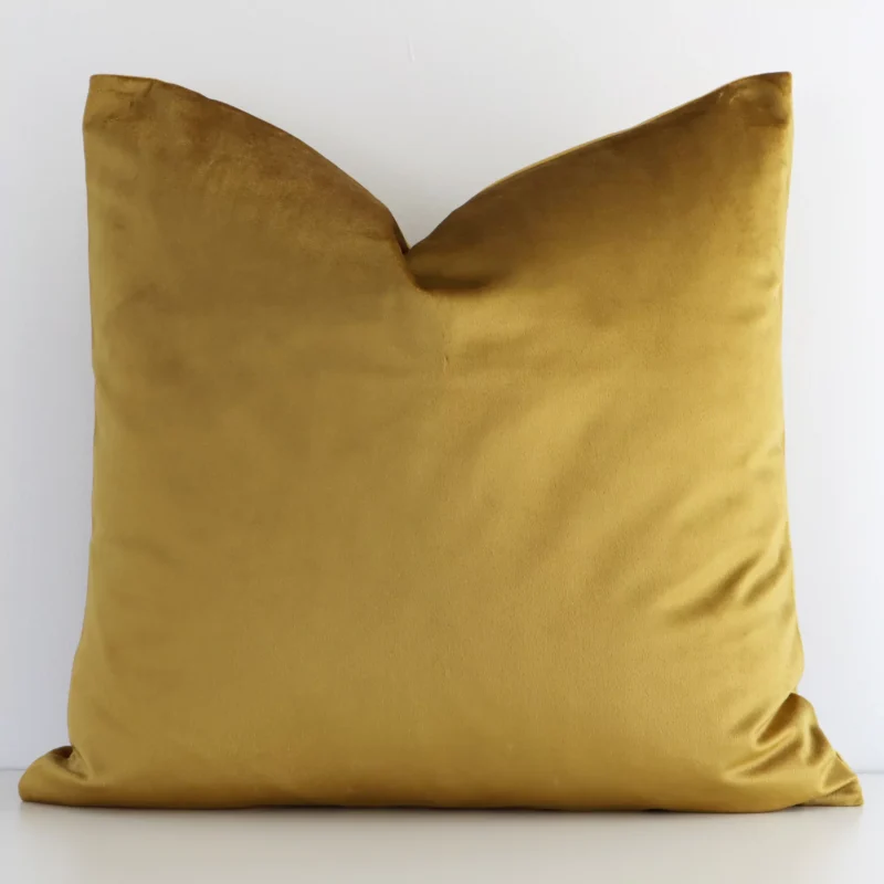 gold-mustard-velvet-linen-cushion-cover---sc509-45 A white wall that has a solid-coloured gold mustard cushion cover positioned in front of it. It has an exquisite velvet material and a lovely square shape.