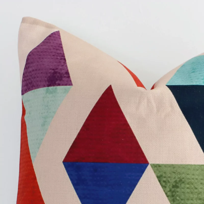 Very close photo of colourful geometric cushion. The shot shows the linen material and square shape's corner with more clarity.
