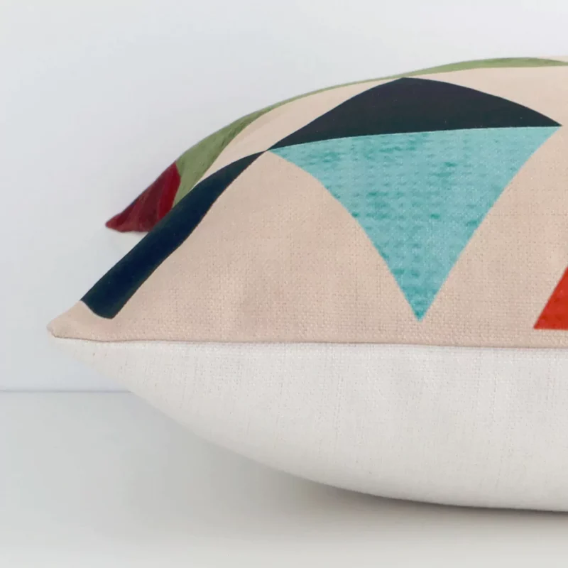 Side edge of geometric square cushion. The linen material and colourful print can be seen from this lateral viewpoint.