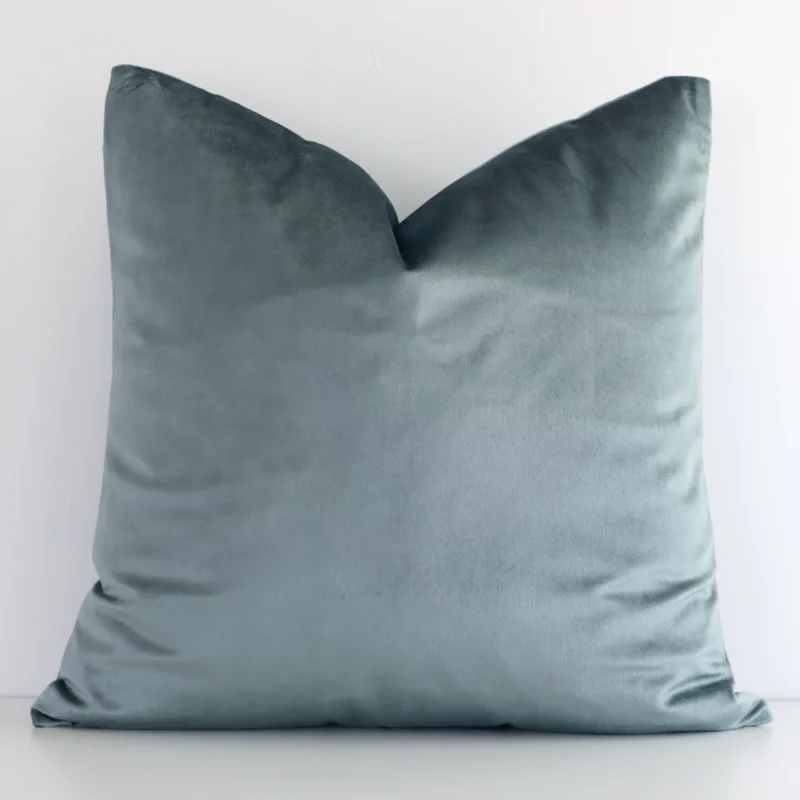 sage-green-velvet-linen-cushion-cover---sc784-45 Sage Green solid-coloured cushion cover sits against a white wall. It is constructed from a superior looking velvet material and has square dimensions.