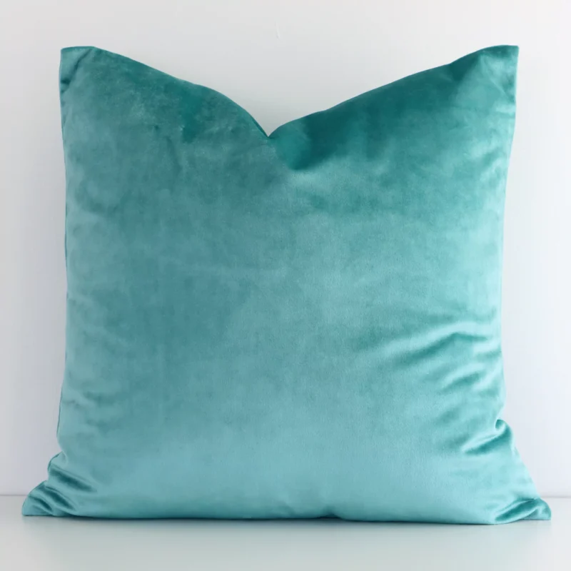 spearmint-velvet-linen-cushion-cover---sc512-45 Spearmint velvet cushion cover features prominently against a white wall. It is a square design.