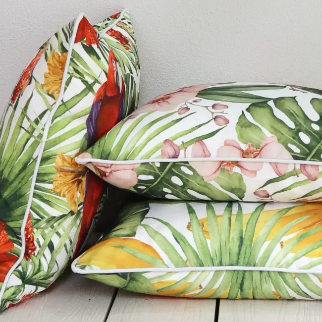 An arrangement of tropical outdoor cushions styled against a wall.
