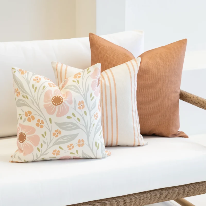 A white sofa showing a set of 3 desert bloom outdoor sofa cushions.