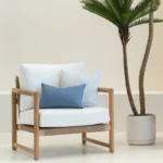 2 pacific blue coloured outdoor cushions are arranged on a single-seater chair.