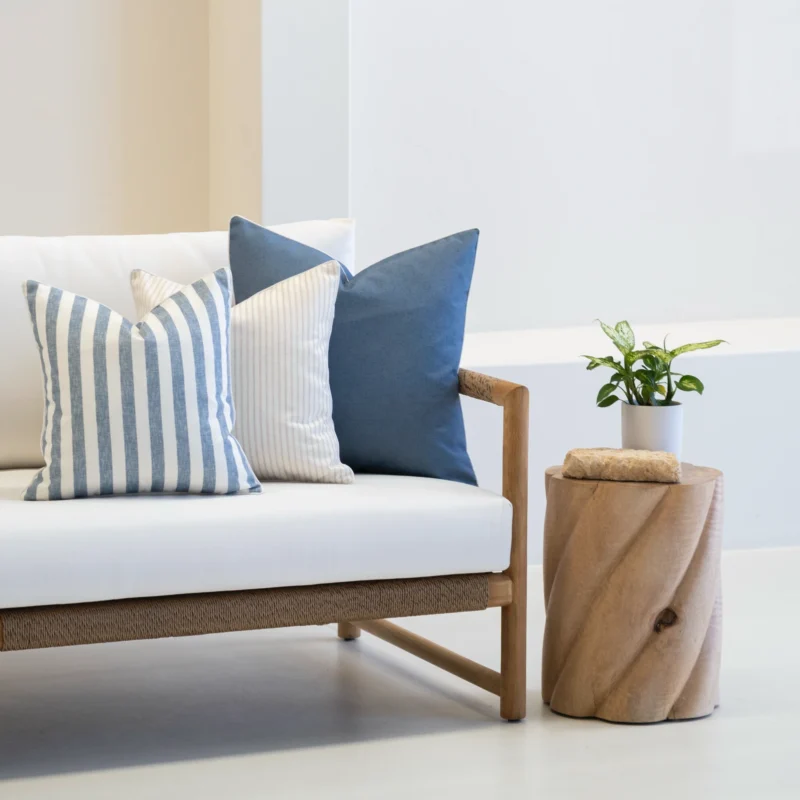 The corner of a white sofa styled with a set of 3 Pacific Cove outdoor cushions.