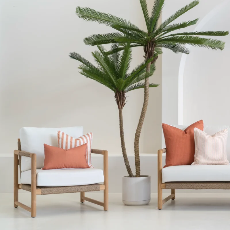 A white outdoor living room showing 4 pacific rust outdoor cushions displayed on a sofa.