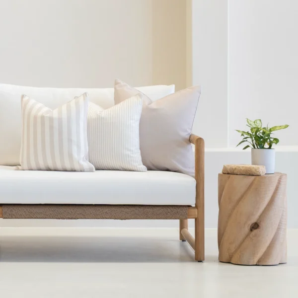 A white couch with a set of 3 outdoor couch cushions in a pacific sand colour.