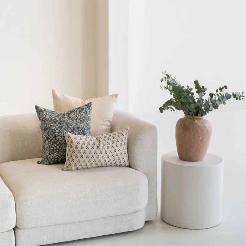 The corner of a natural sofa with 3 designer covers from the Sable set.