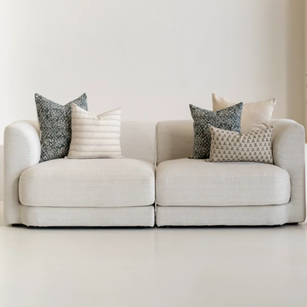 The Sable designer set of 5 sofa cushions is styled on a natural-coloured sofa.