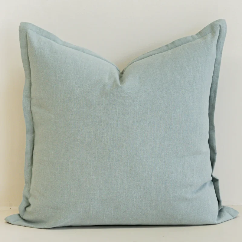 Close-up of eucalyptus blue linen cushion with soft textured finish.