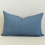 Pacific blue rectangular cushion with white piping on plain background.