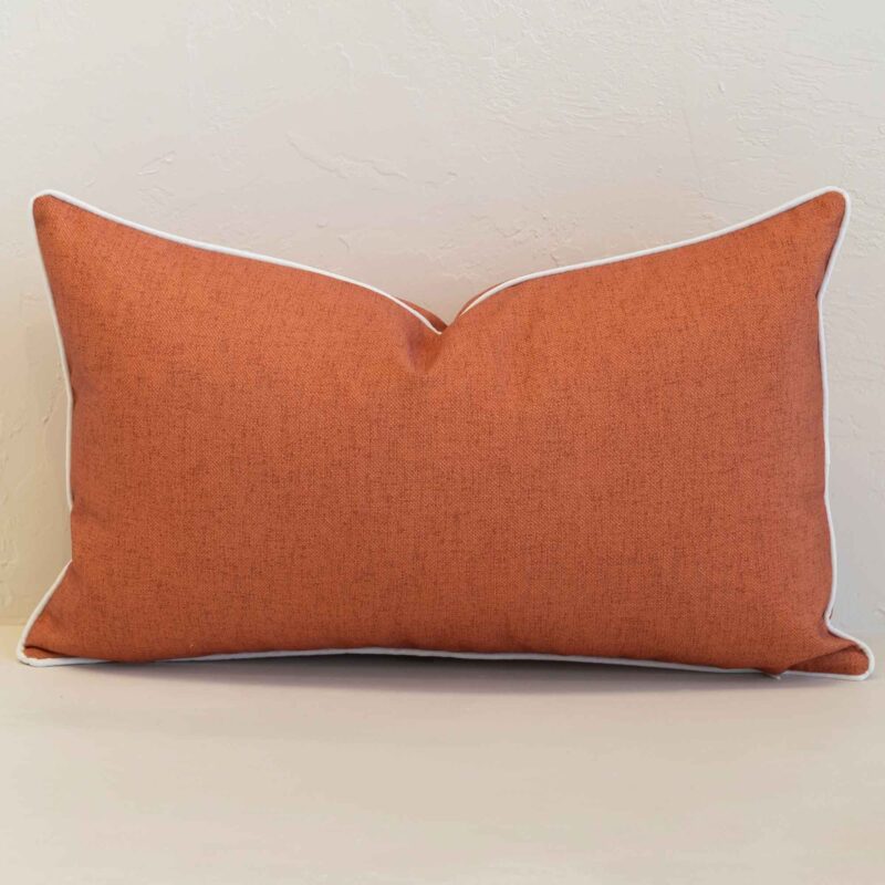 pacific-waterproof-rust-outdoor-cushion-cover-–-rectangle-sc1058-30 Pacific rust rectangular cushion with textured fabric and white piping edges.
