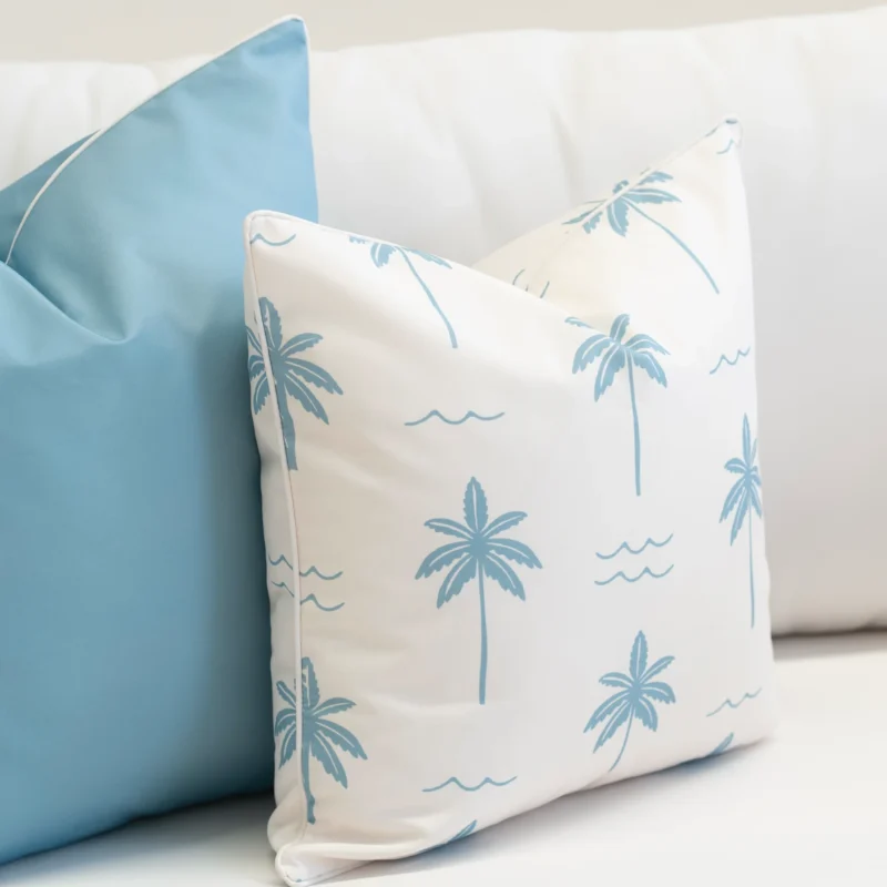 Close-up of Tropica aqua cushion with palm tree pattern and light blue design.