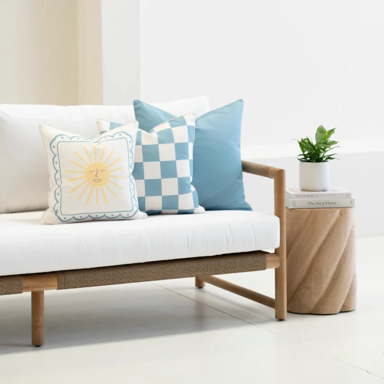 Tropica aqua cushions with sun motif, check pattern and plain blue on sofa.