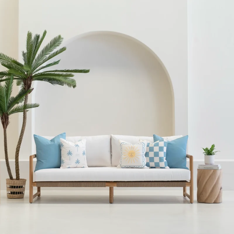 Tropica aqua cushions styled on outdoor sofa with blue and white patterns.