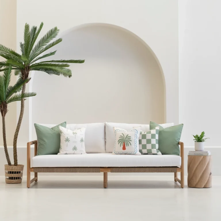 Tropica green cushions styled on outdoor sofa with palm and check patterns.