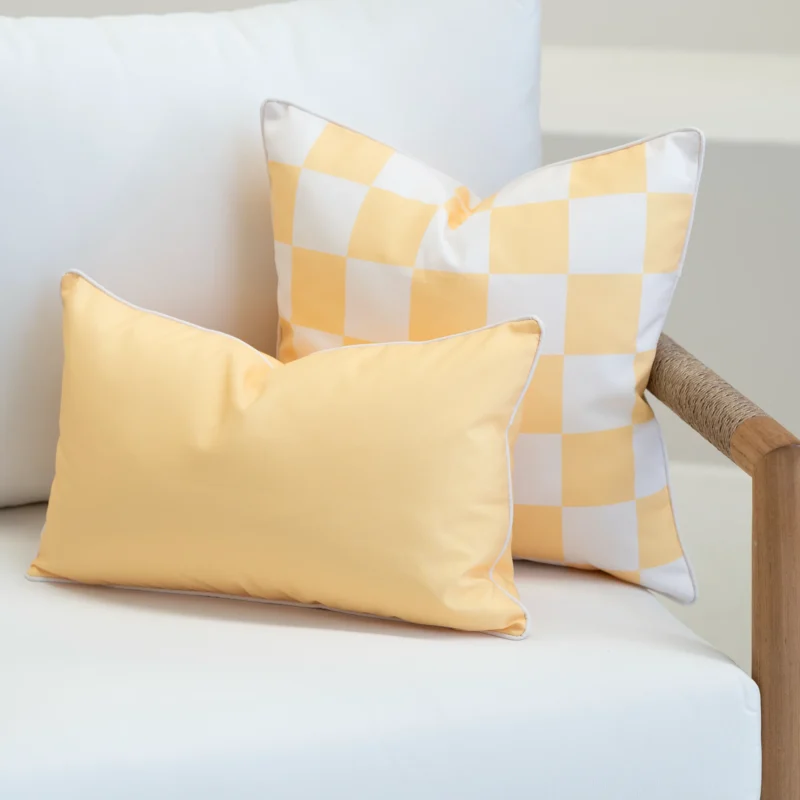 Tropica lemon yellow cushions with gingham check and solid rectangular cushion on sofa.