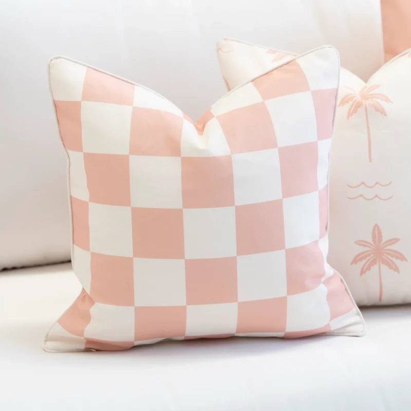 Tropica pink check cushion with soft white squares on outdoor seating.