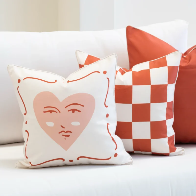 Tropica red cushions with heart motif and check pattern on white sofa.