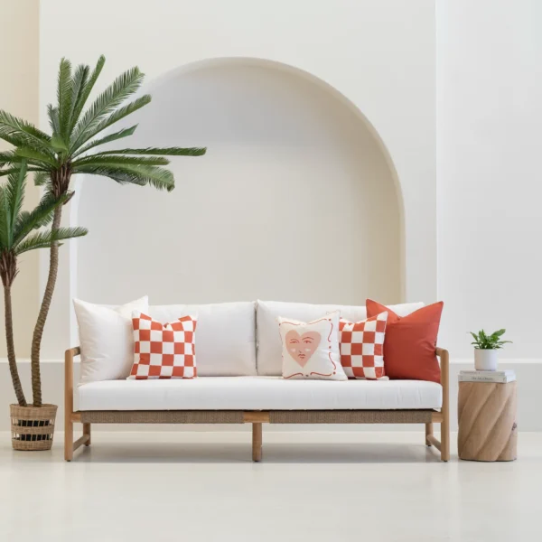 Tropica red outdoor cushions with checker and heart patterns on white sofa.