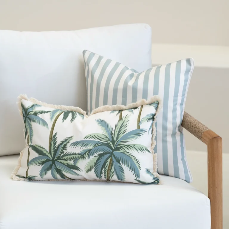 Wildgrove Palm cushions with palm print and blue striped cushions on sofa.