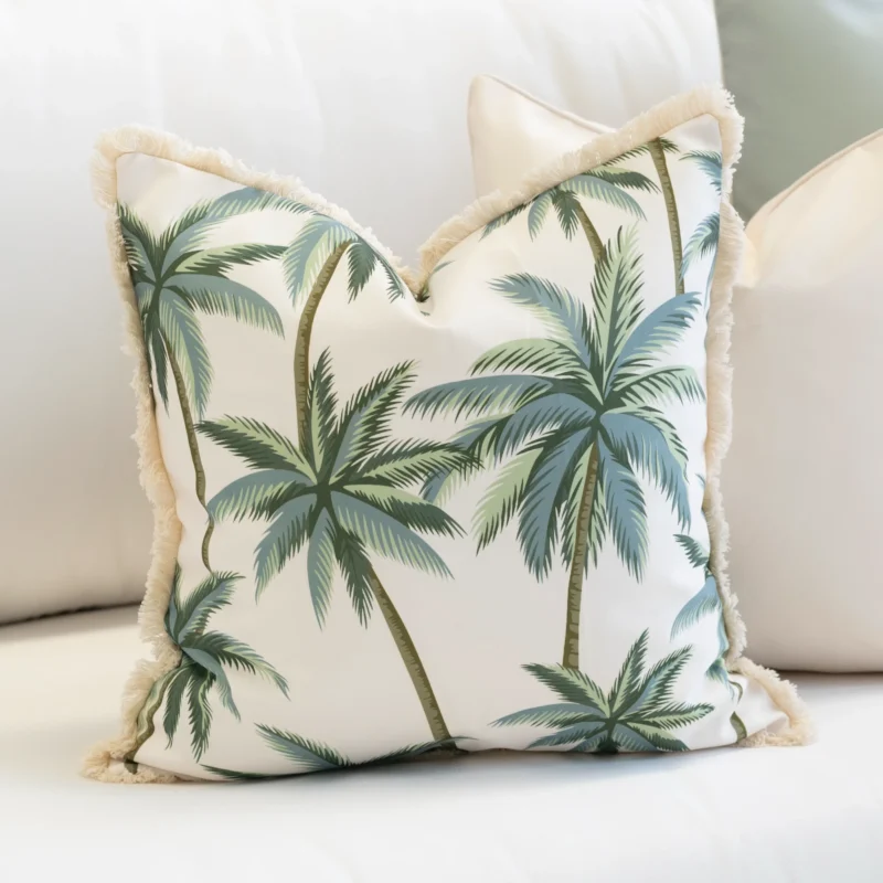 Close-up of Wildgrove Palm cushion with green palm tree pattern and fringe edge.