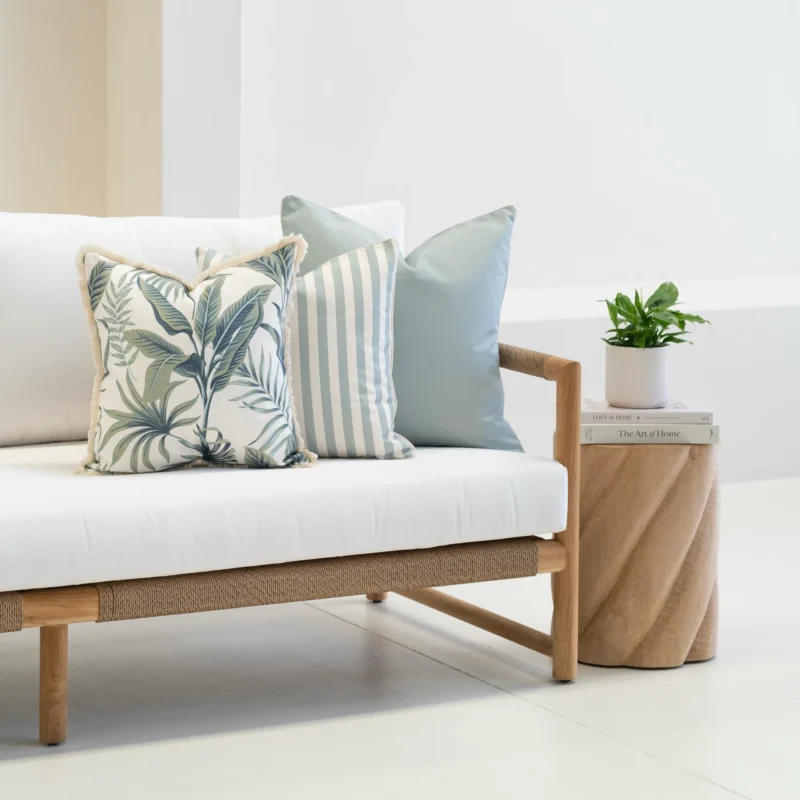 Wildgrove Palm cushions styled on sofa with striped and botanical patterns.