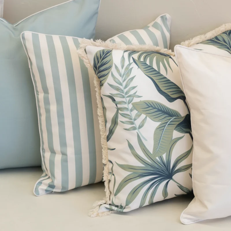 Close-up of Wildgrove Palm cushions showing botanical print and blue stripes.