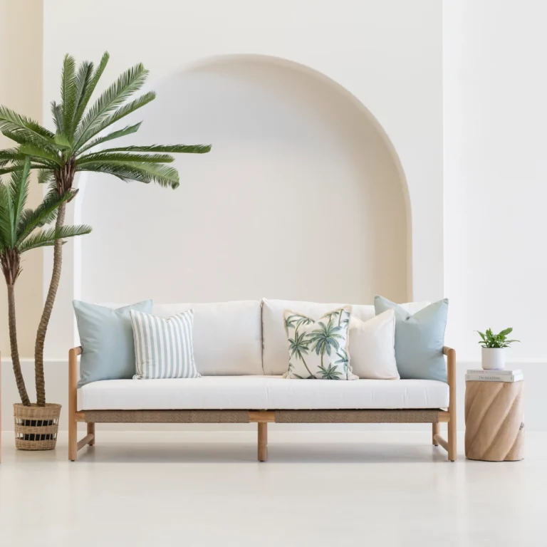 Wildgrove Palm cushions with soft blue tones and palm prints on sofa.