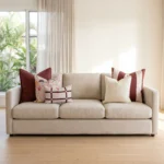 Five-piece cushion set with burgundy linen and mulberry stripe blocks, cream and floral prints, and a checked lumbar, on a sofa.
